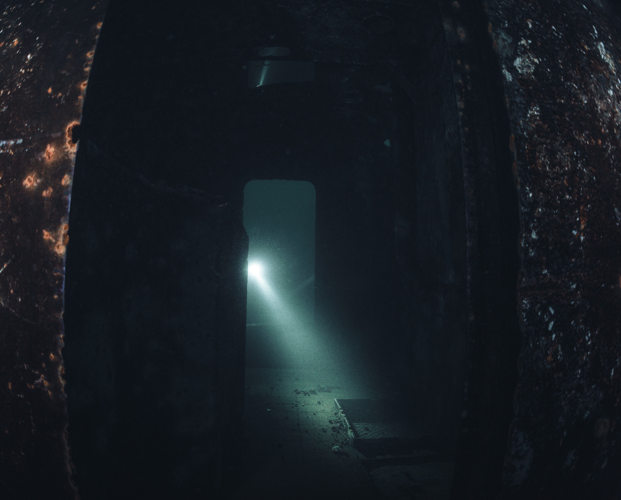 A torch beam through a wreck doorway