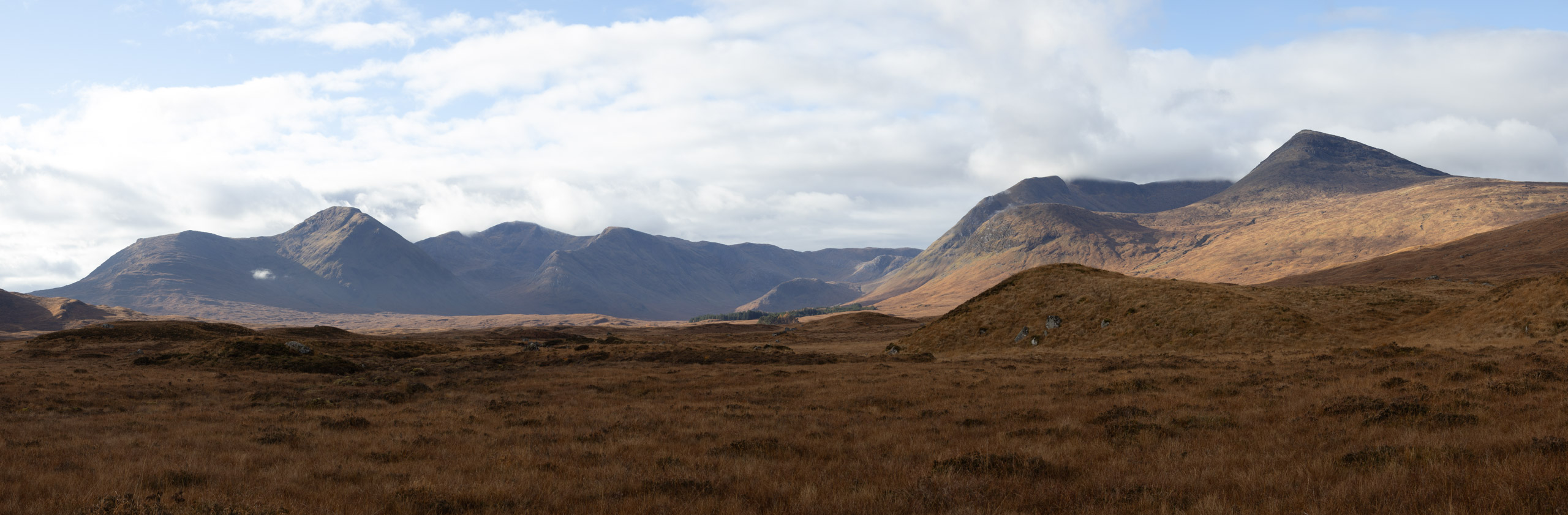 Highland mountain range under broken cloud
