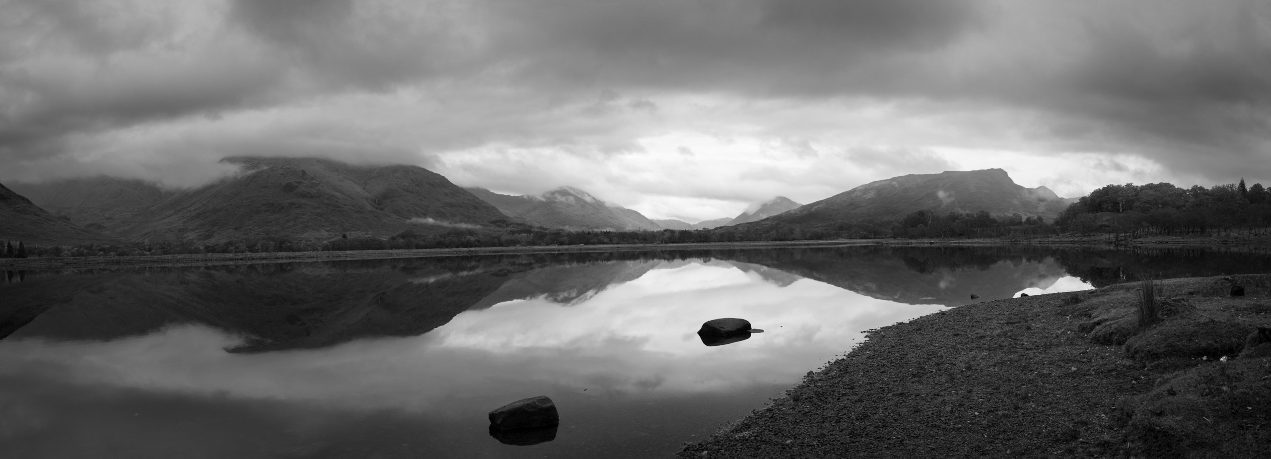 A still Scottish loch in black and white
